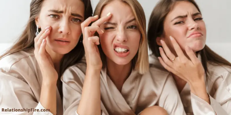 Three women looking at pimples in the mirror - What Is a Love Pimple